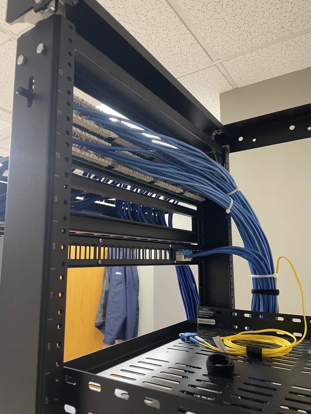 Terminated patch panel with dressed Cat6 runs and fiber at a wall-mount rack