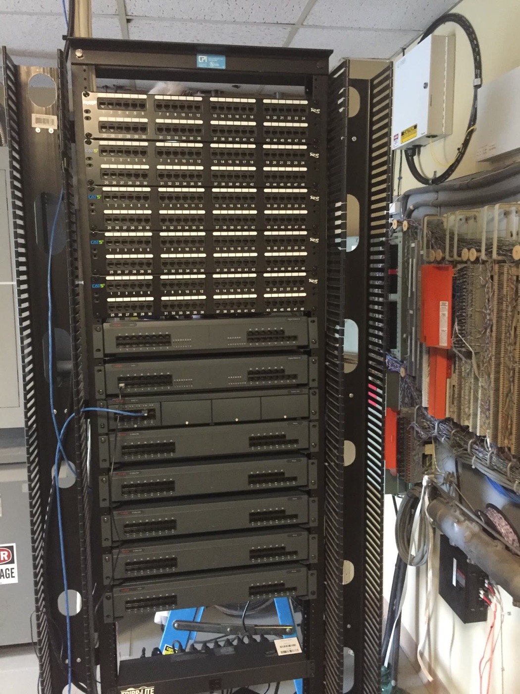 Full-height rack pairing legacy voice equipment with certified Cat5e data panels